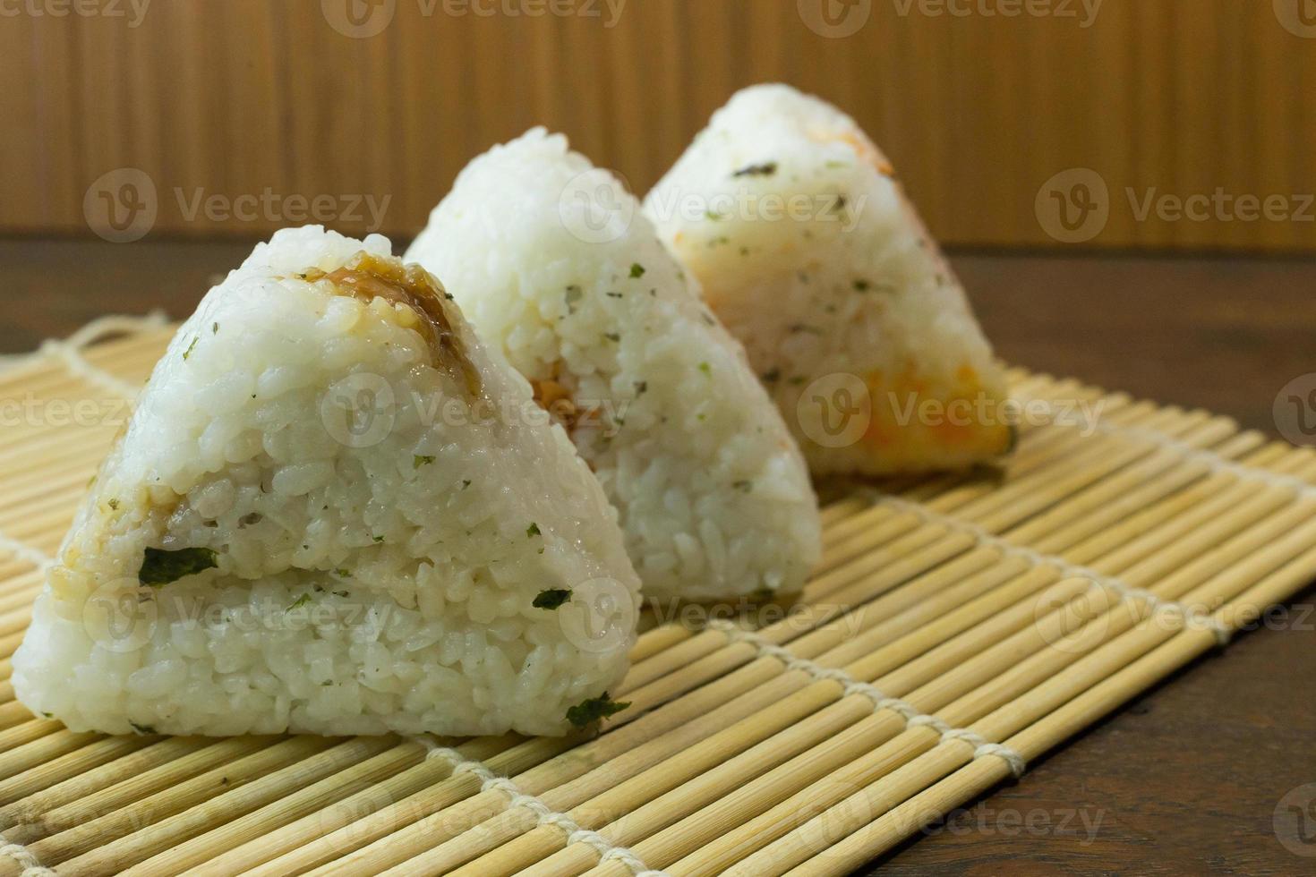 la comida japonesa onigiri arroz blanco formado en formas triangulares o cilíndricas y, a menudo, envuelto en nori. foto