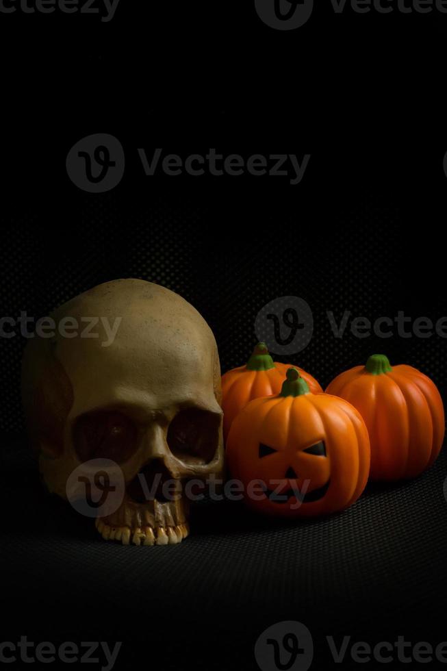 The halloween pumpkin jack and skull in black holiday background image. photo