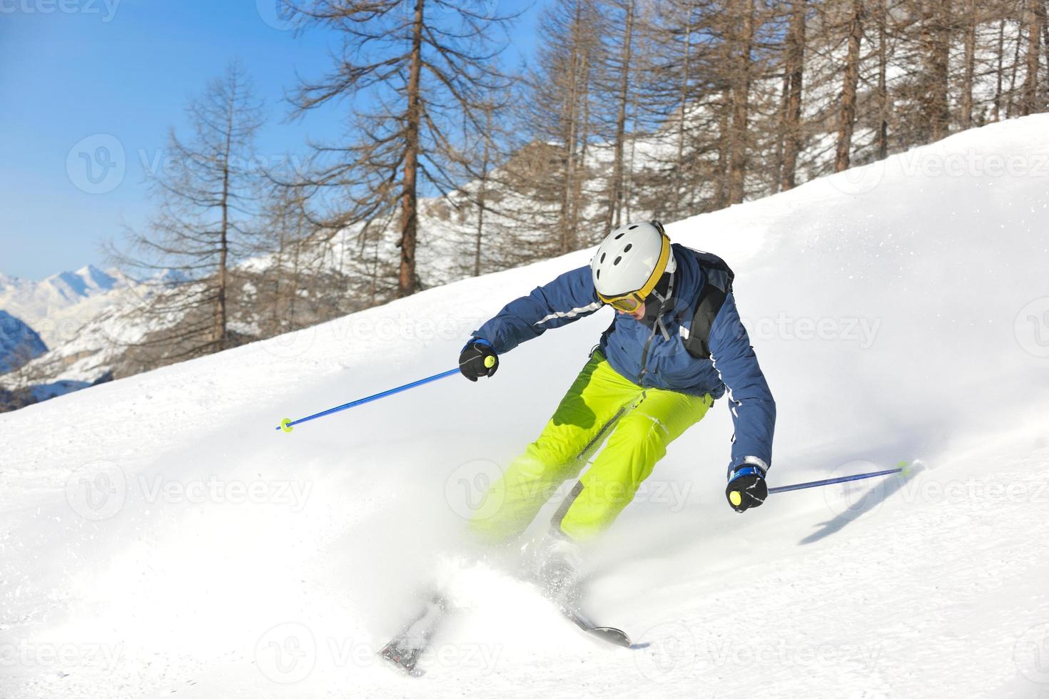 esquiar en nieve fresca en la temporada de invierno en un hermoso día soleado foto