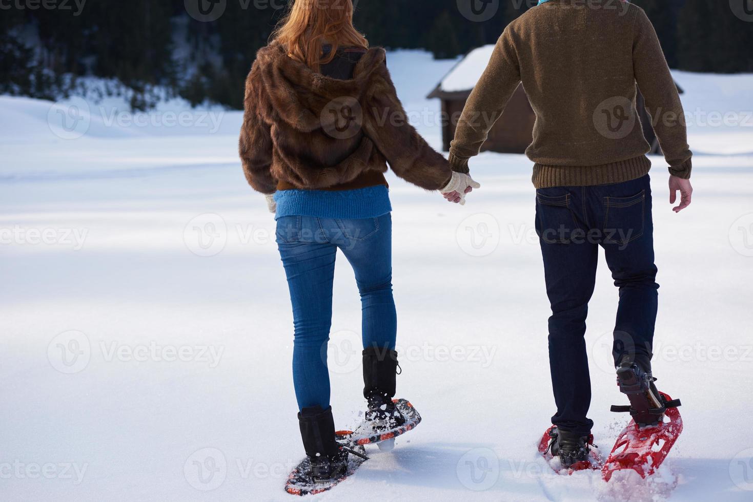 pareja divirtiéndose y caminando con raquetas de nieve foto