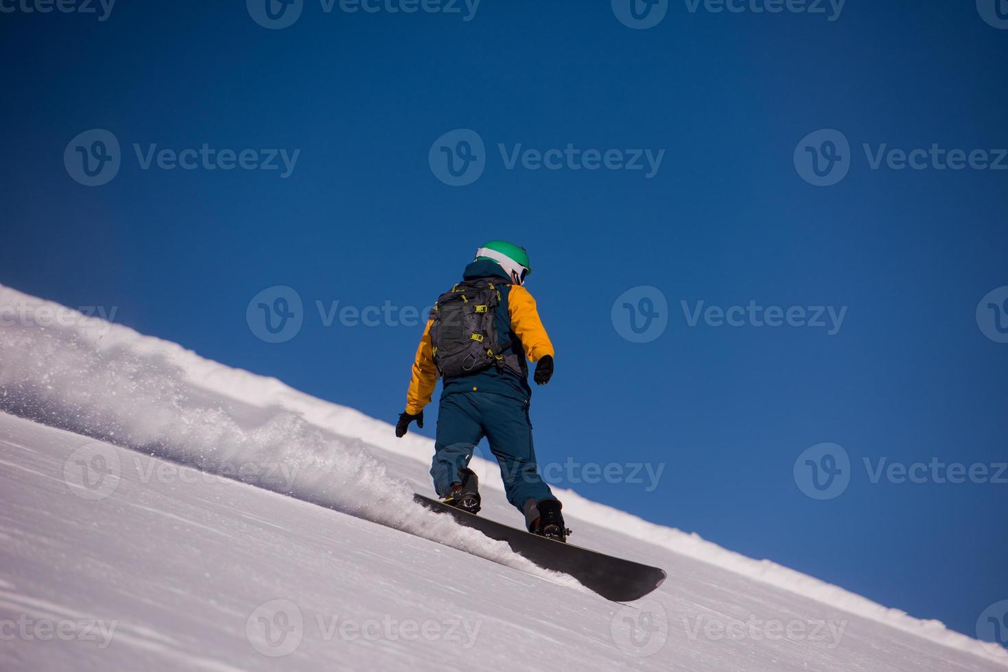 snowboarder running down the slope and ride free style photo