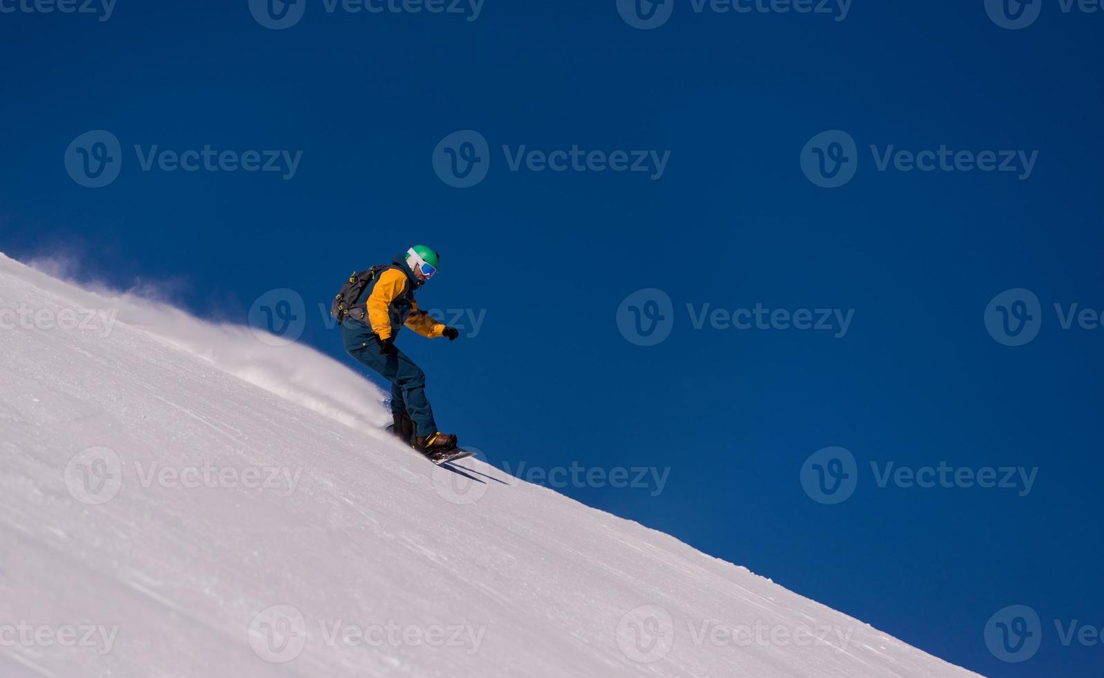 snowboarder corriendo por la pendiente y montando estilo libre foto