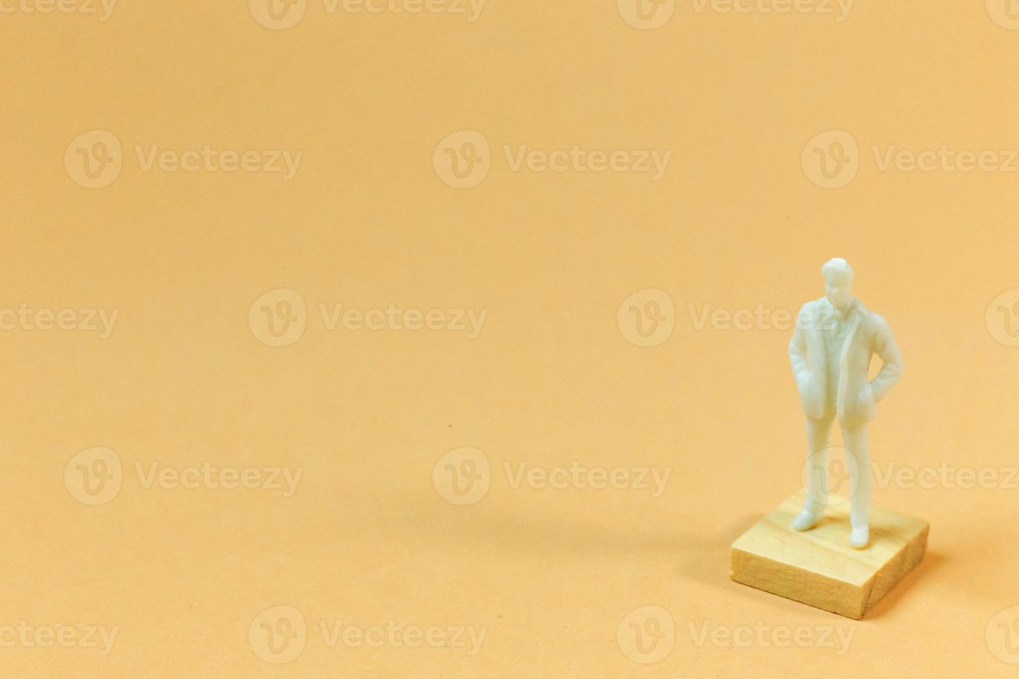 white  figure miniature on orange pastel for business content. photo