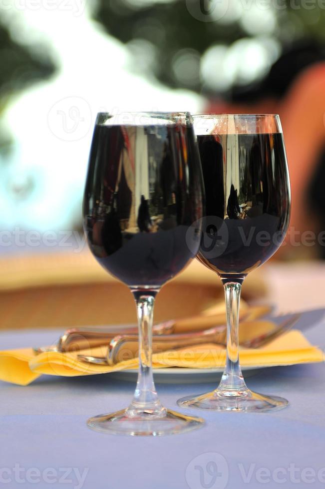 two glasses in outside restaurant with black wine photo