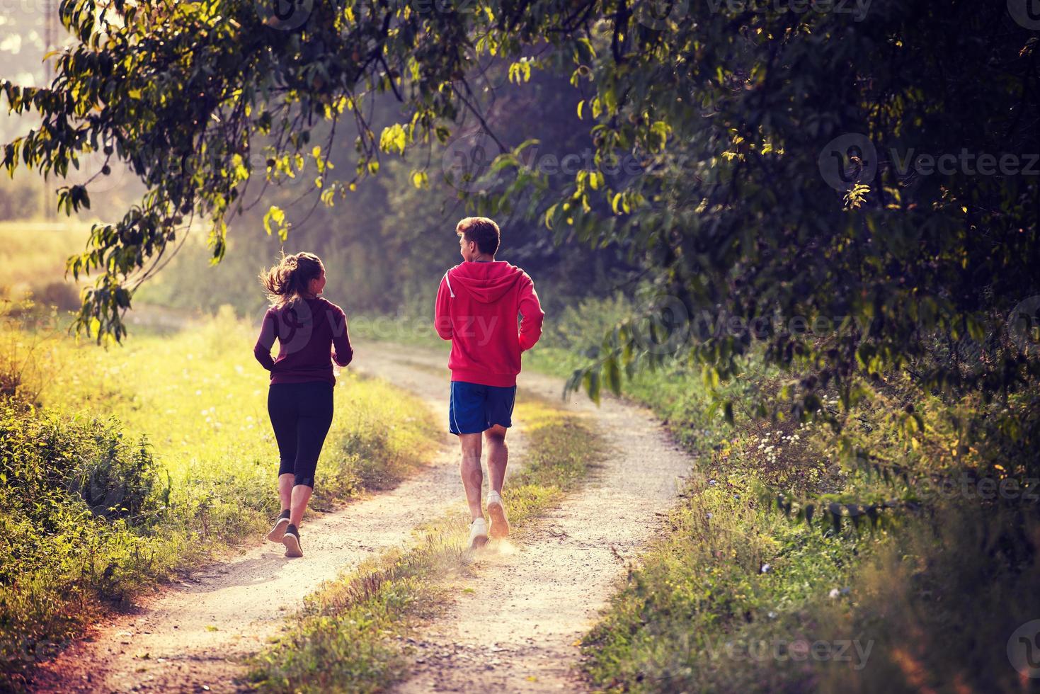 young couple jogging along a country road photo