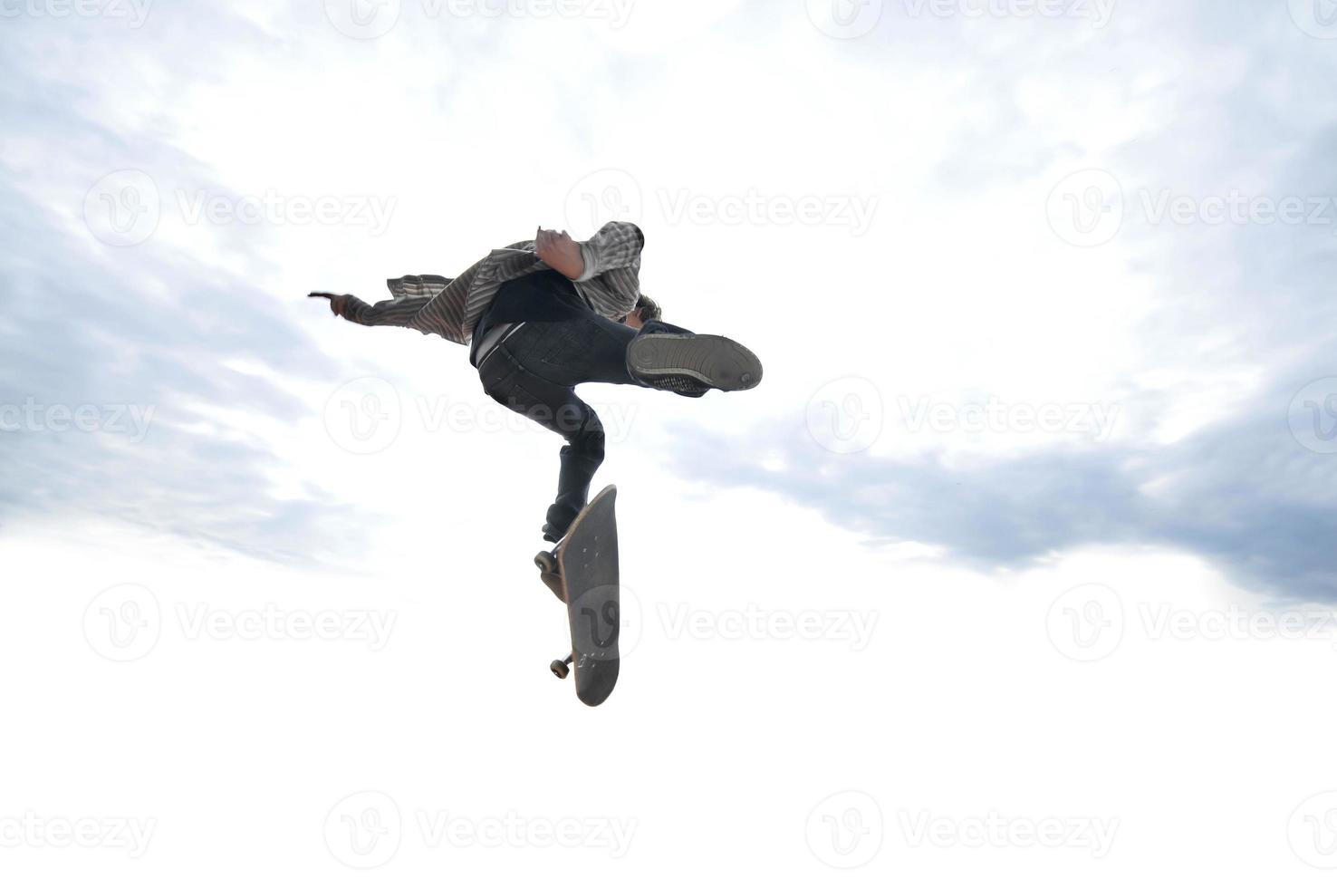 Boy practicing skate in a skate park photo