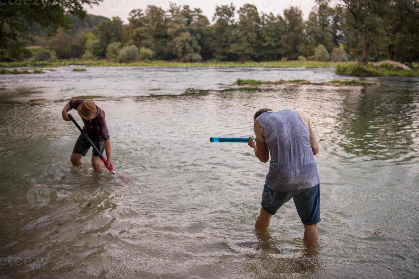 jóvenes divirtiéndose con pistolas de agua foto