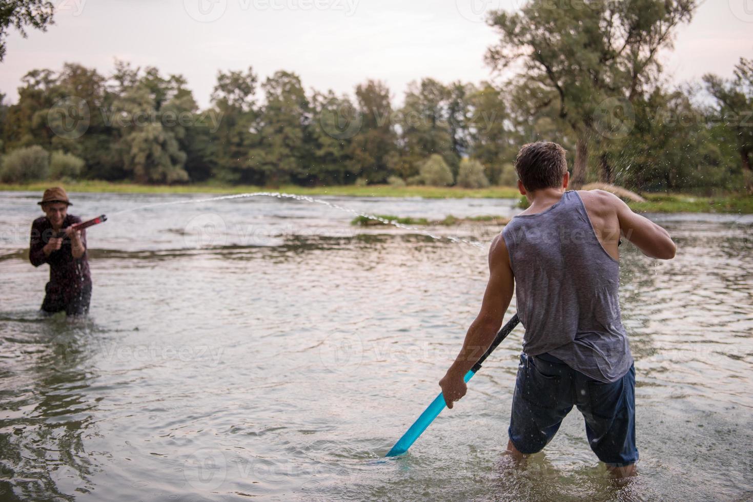 jóvenes divirtiéndose con pistolas de agua foto