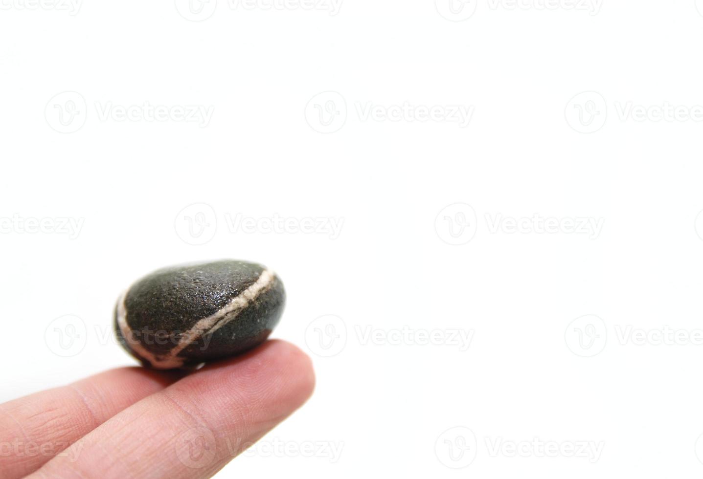 .zen stone on finger representing balance concept photo