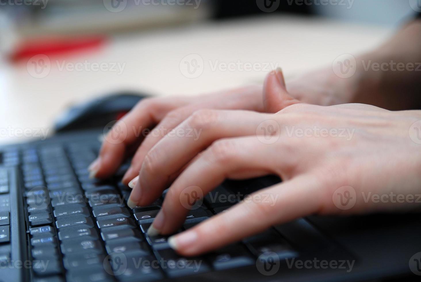 manos de mujer escribiendo en el teclado de la computadora portátil foto