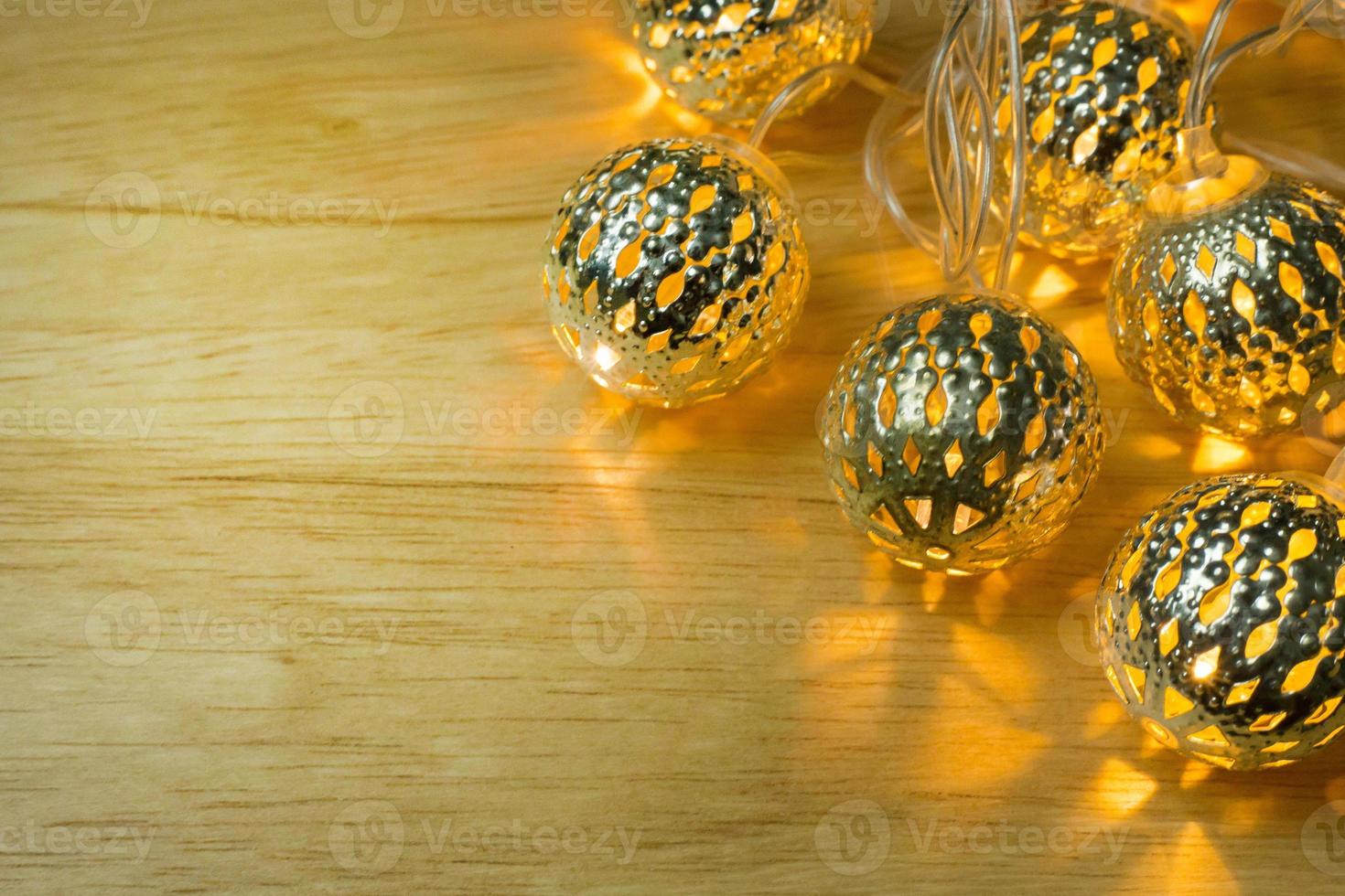Christmas gold lights ball decor on wood table. photo