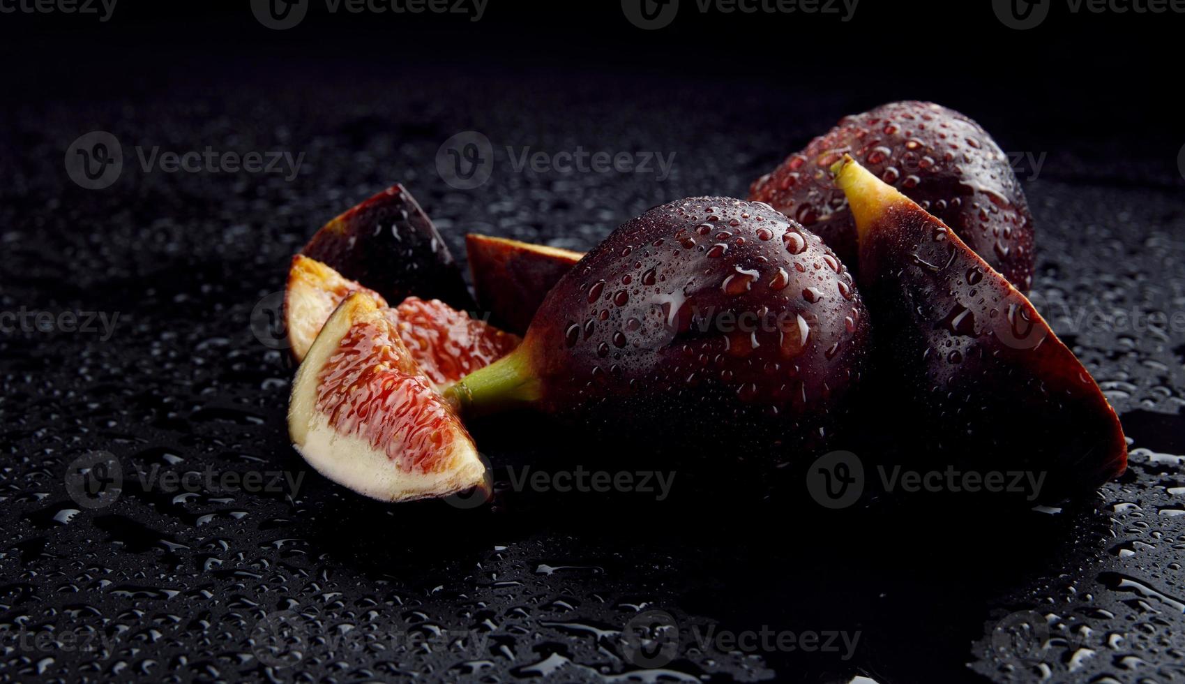 Whole and cut into pieces of figs. ripe figs with water drops on the peel. photo