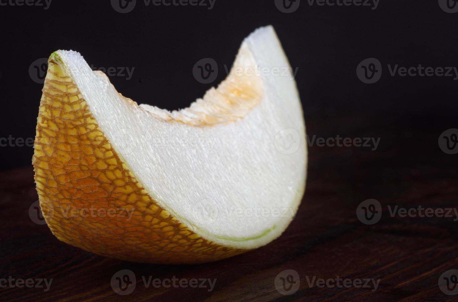 A beautiful piece of ripe melon on a wooden table. photo