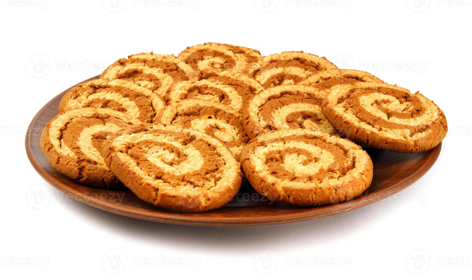 A clay plate with cookies is isolated on a white background. Cookies with a beautiful spiral pattern. photo