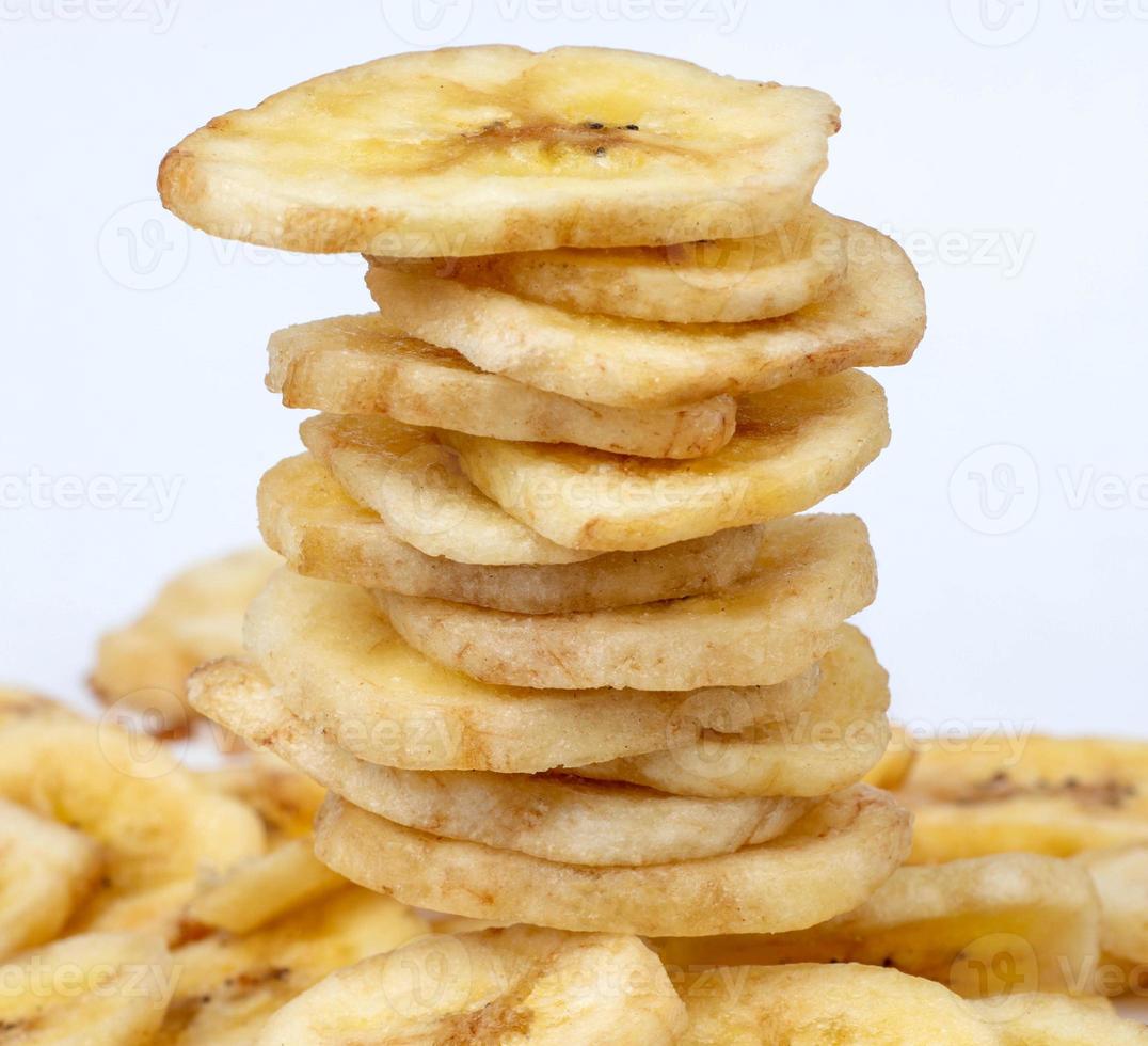 A stack of banana chips stands on a bunch of chips. photo