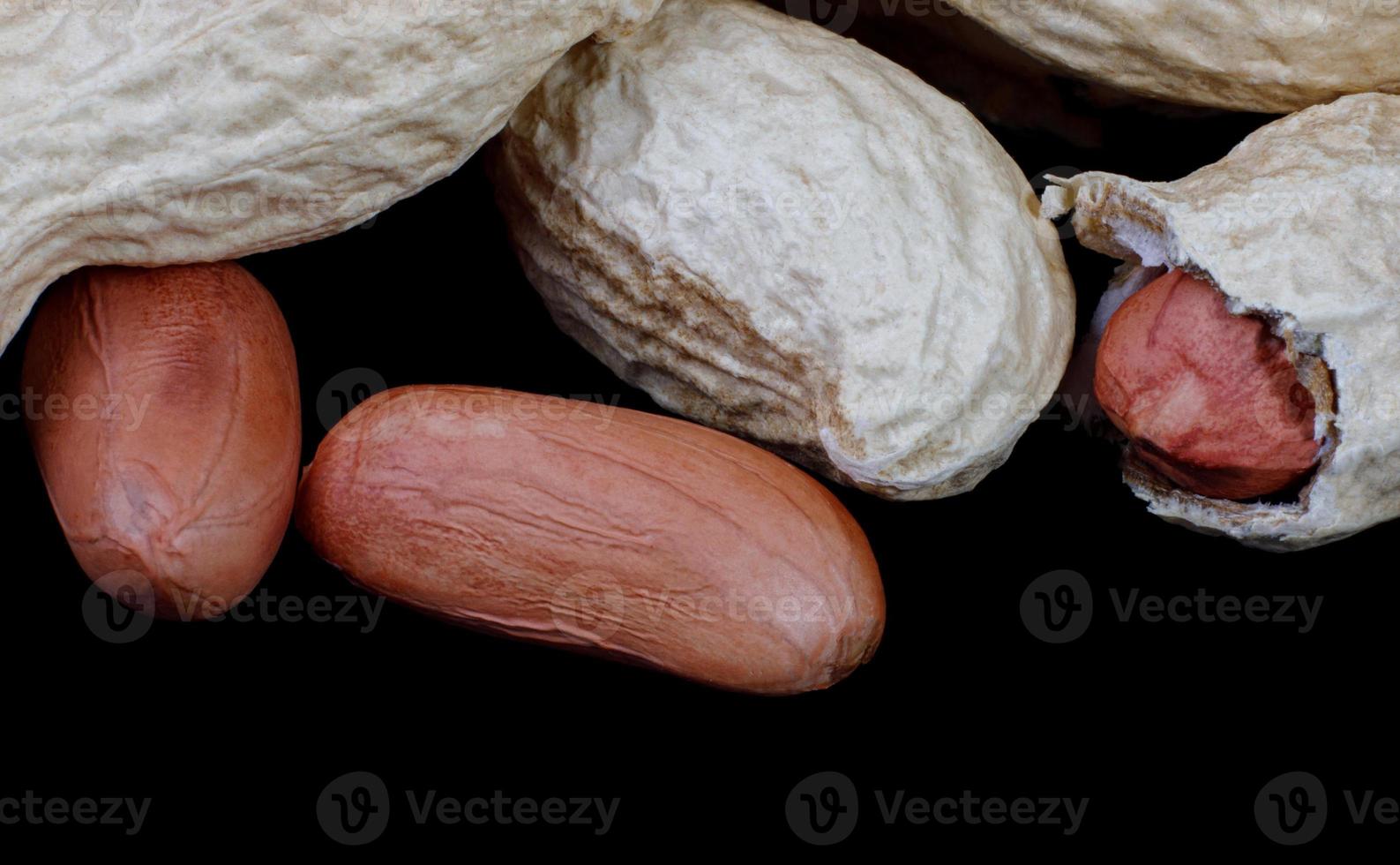 Peanuts in the shell and without it on a black background. photo