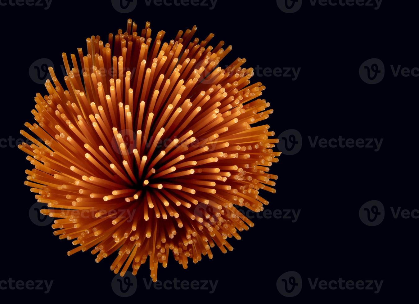 A bunch of tomato pasta on a dark background. Colored spaghetti. photo