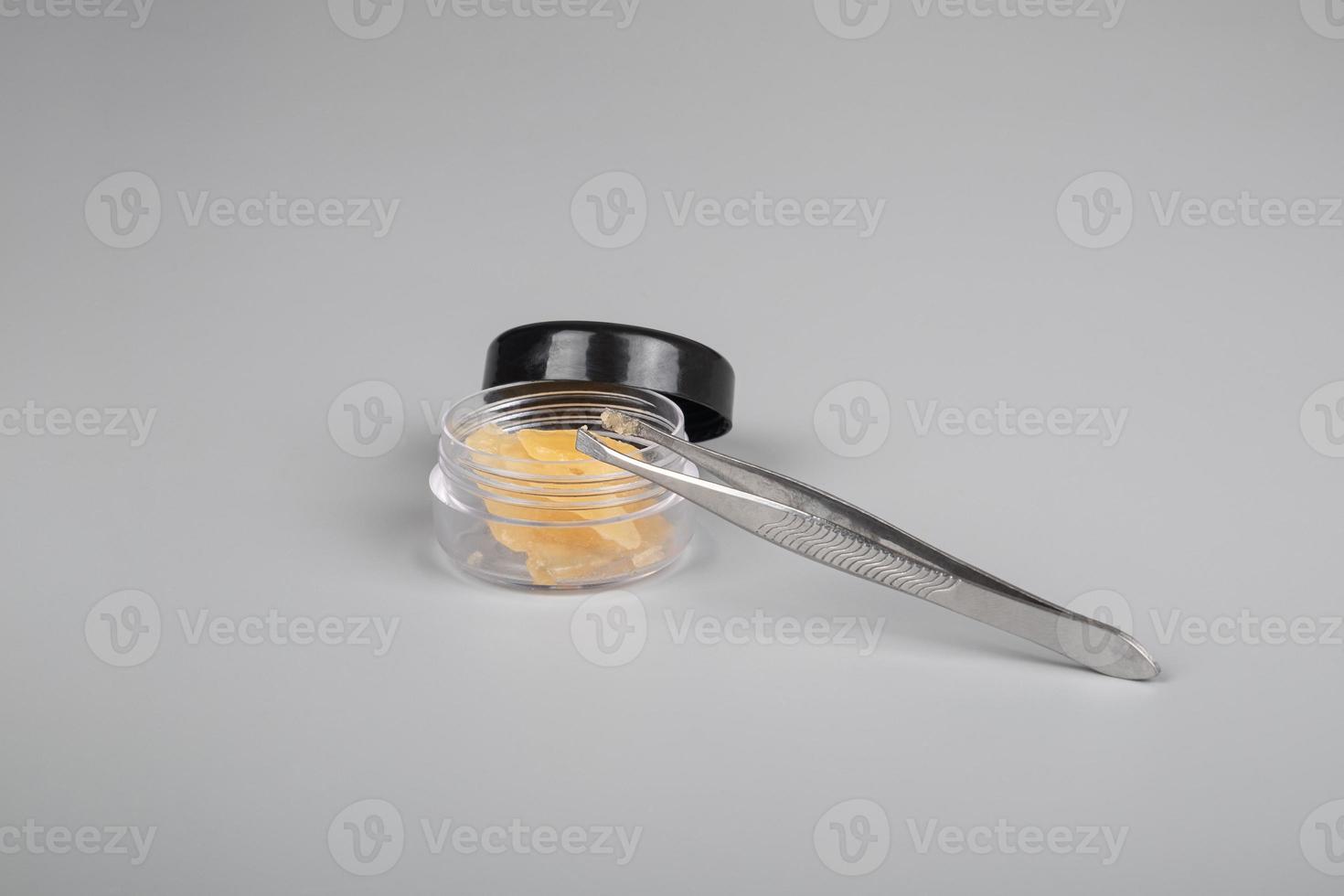 cannabis extract in container for smoking gray background photo