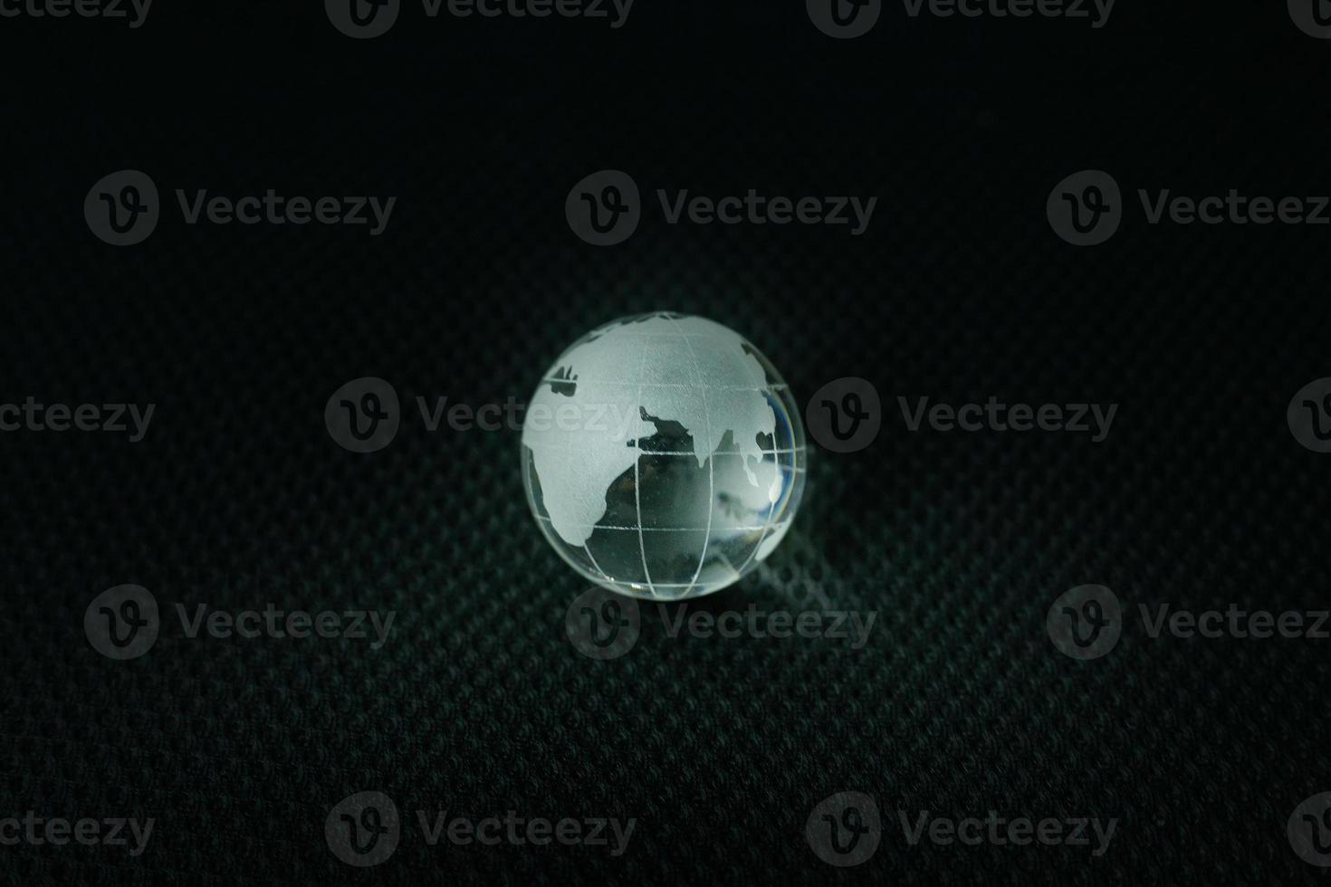 glass ball planet earth in black background. photo