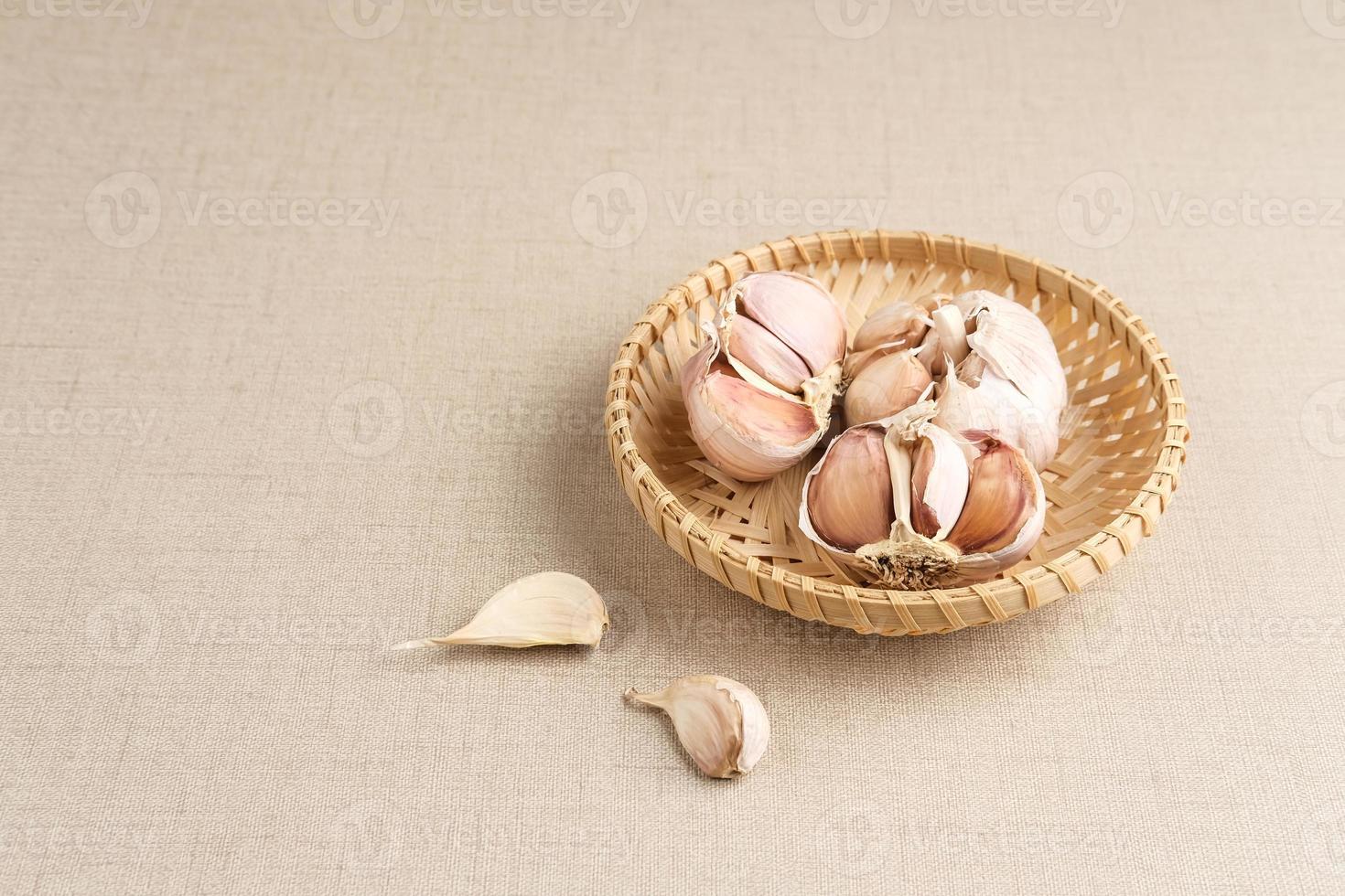Lots of fresh garlic on bamboo basket. Close up and copy space. photo