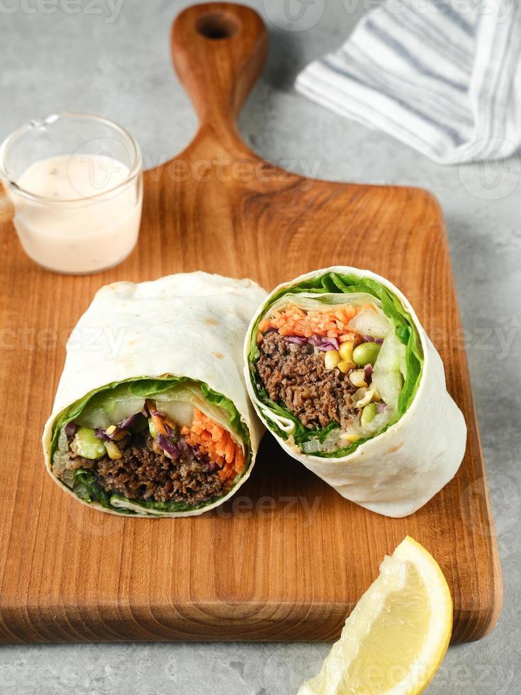 envoltura de ensalada wraps de tortilla con carne teriyaki y verduras frescas. foto