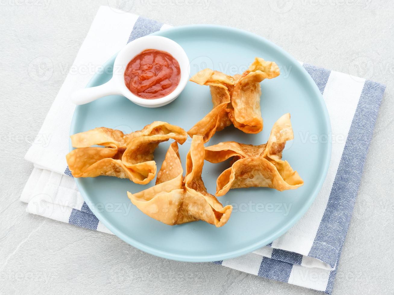 pangsit, pangsit goreng, delicioso pangsit ayam goreng, bola de masa frita de pollo, comida tradicional indonesia hecha de harina y pollo. servido con salsa foto