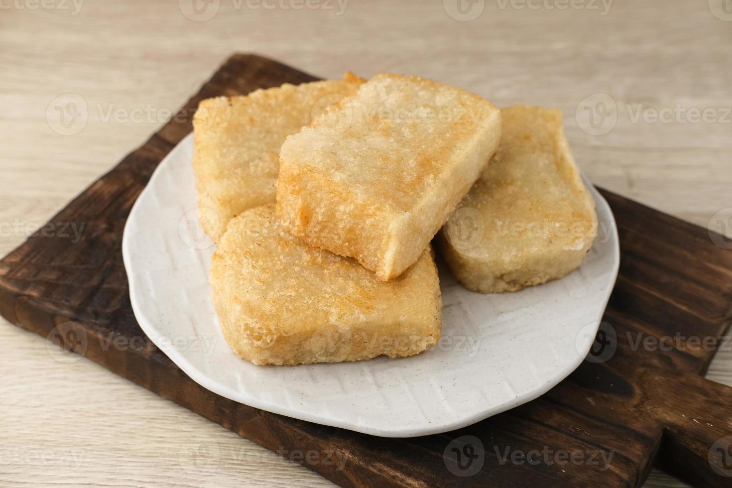 Jadah Goreng or Fried sticky rice cake is Javanese traditional cake made from glutinous rice and grated coconut. Served in white plate photo