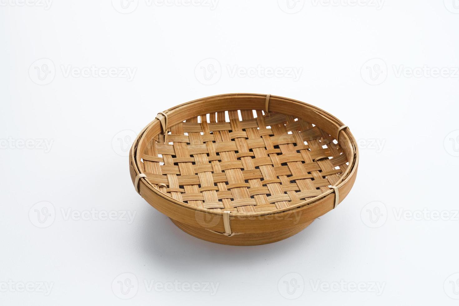 Traditional wicker plate made of bamboo isolated on a white background. Copy space. photo