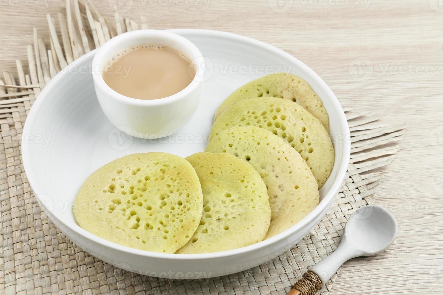 Serabi or Surabi,  Indonesian pancake made of flour, rice flour and coconut milk. Served with palm sugar sauce. Sweet and savory. photo