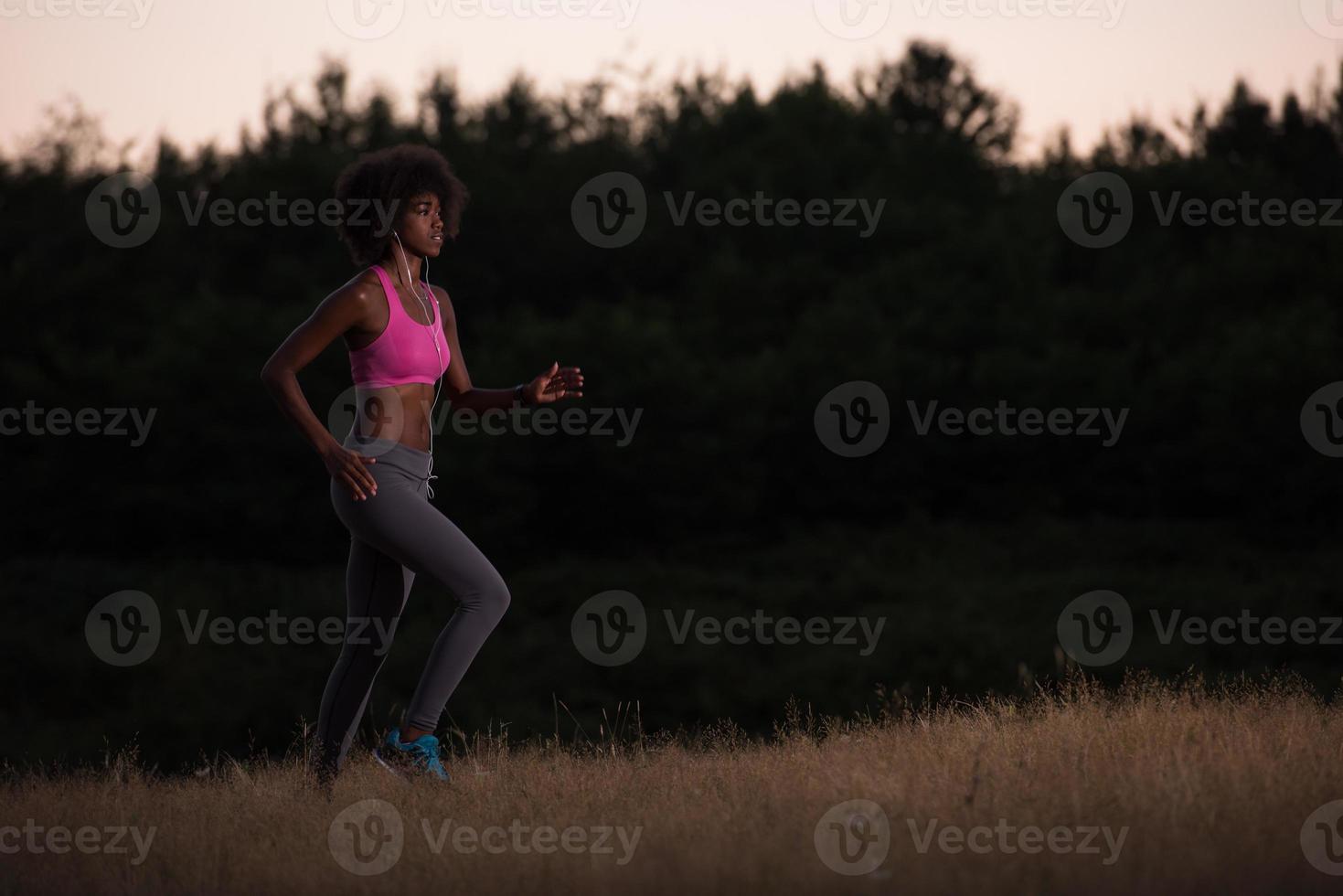 Young African american woman jogging in nature photo