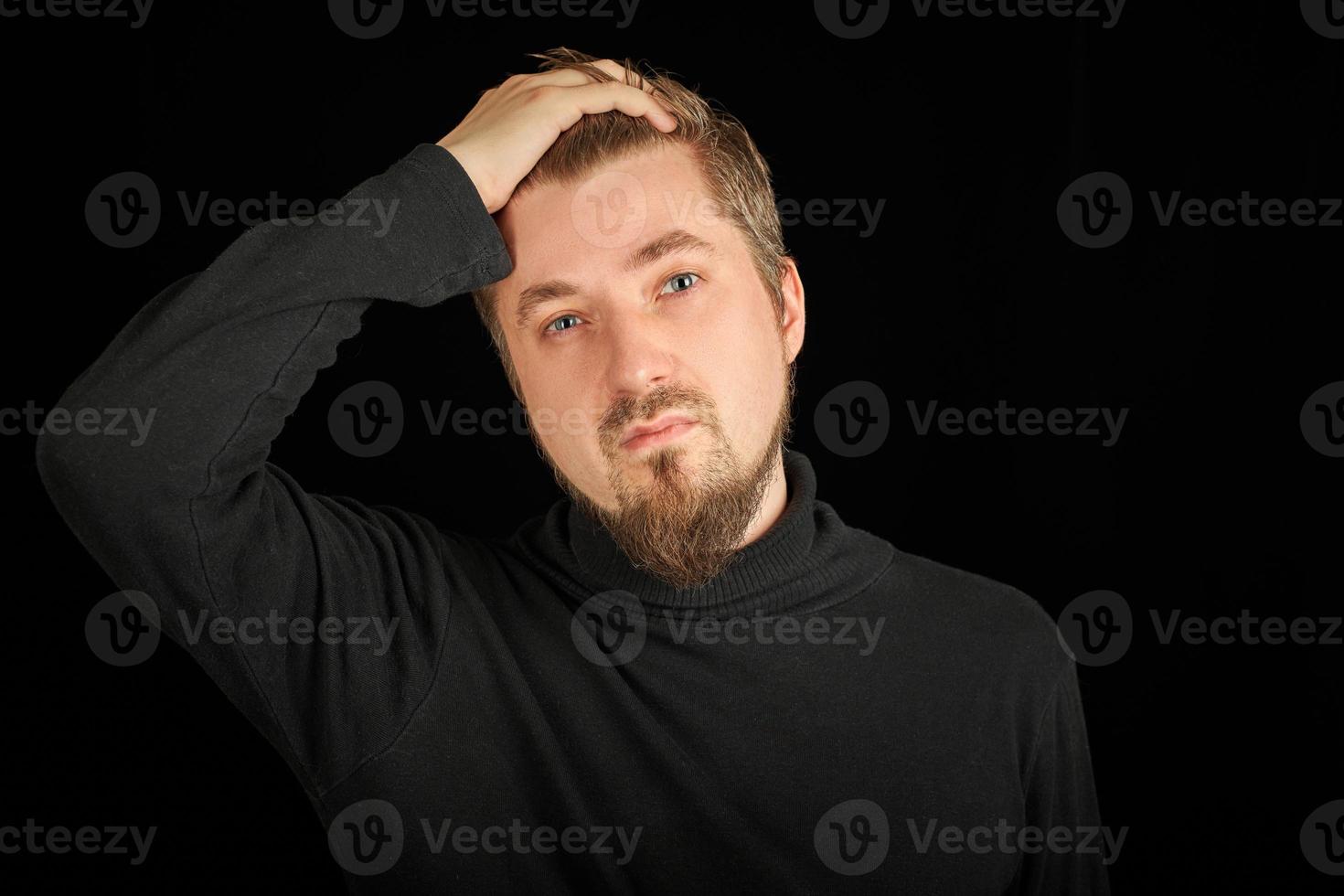 Overworking, head pain concept. Young guy in black polo neck sweater. photo