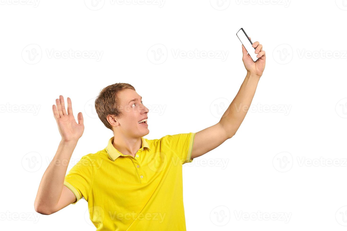 tipo gracioso con una camiseta amarilla brillante chateando en video usando una videollamada con el teléfono, un joven sonriente foto