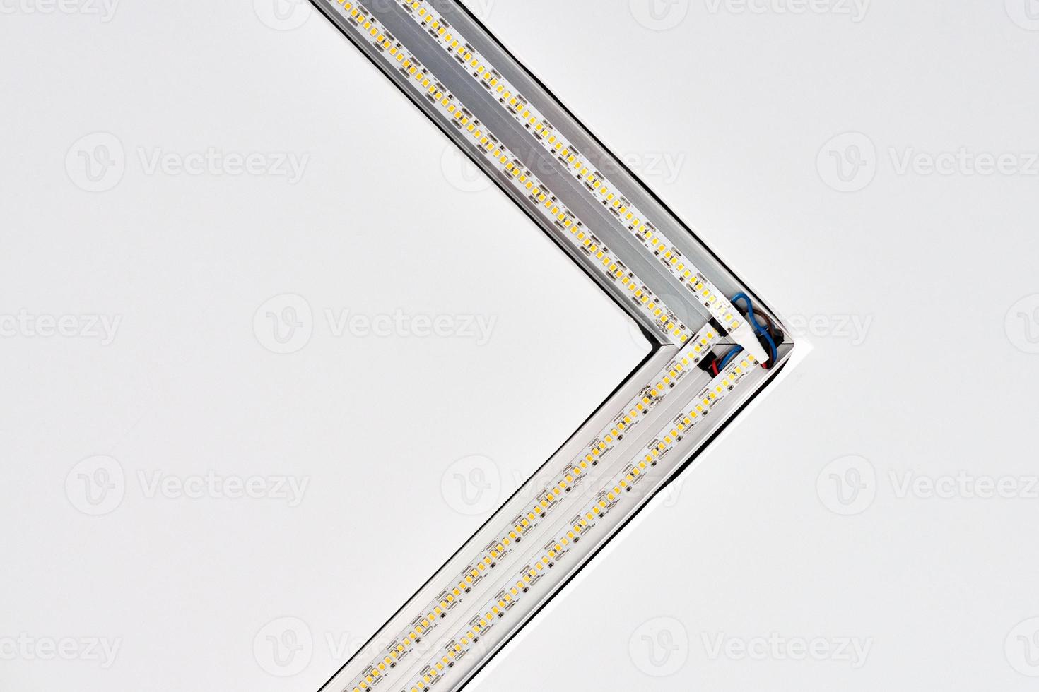 Strip LED lamp lighting with square aluminum profile on suspended ceiling in house, fragment, close photo