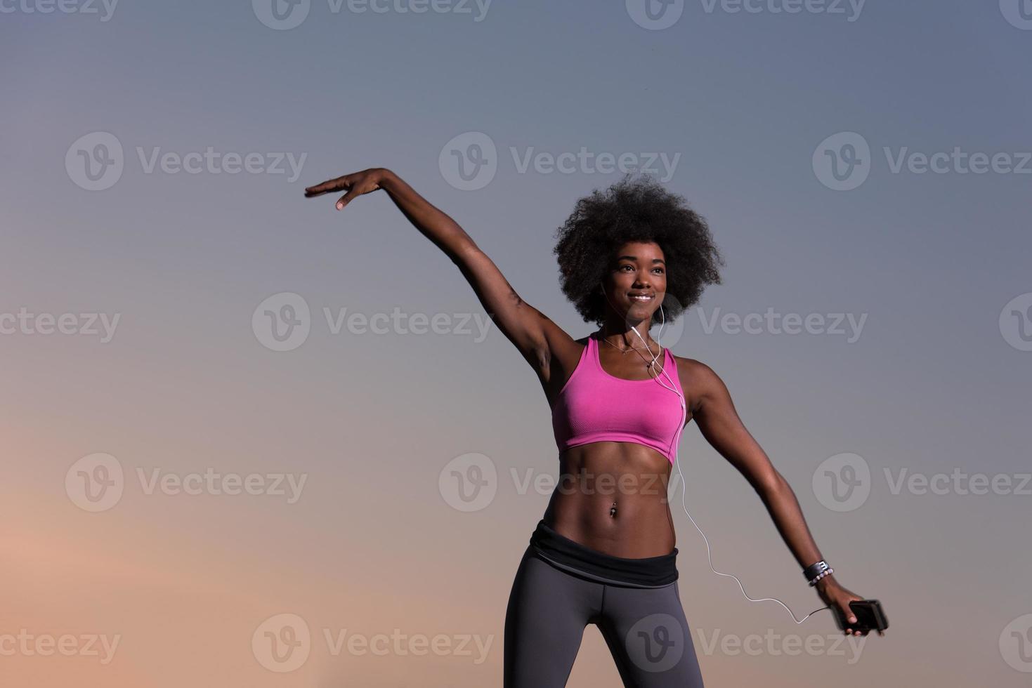 mujer negra está haciendo ejercicio de estiramiento relajándose y calentándose foto