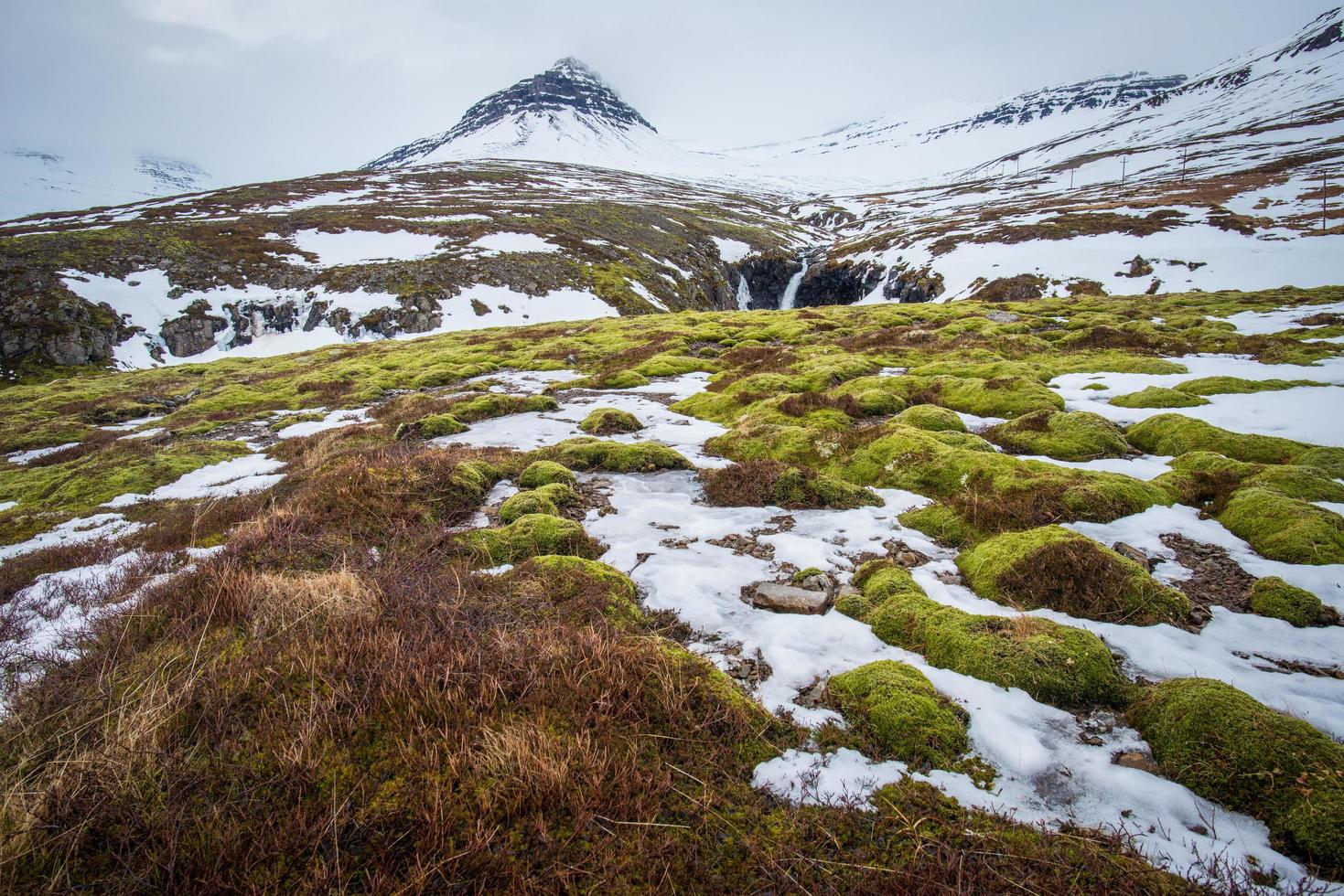 el hermoso paisaje de la montaña nevada en stodvarfjordur del este de islandia cubierto de niebla en la temporada de invierno. foto