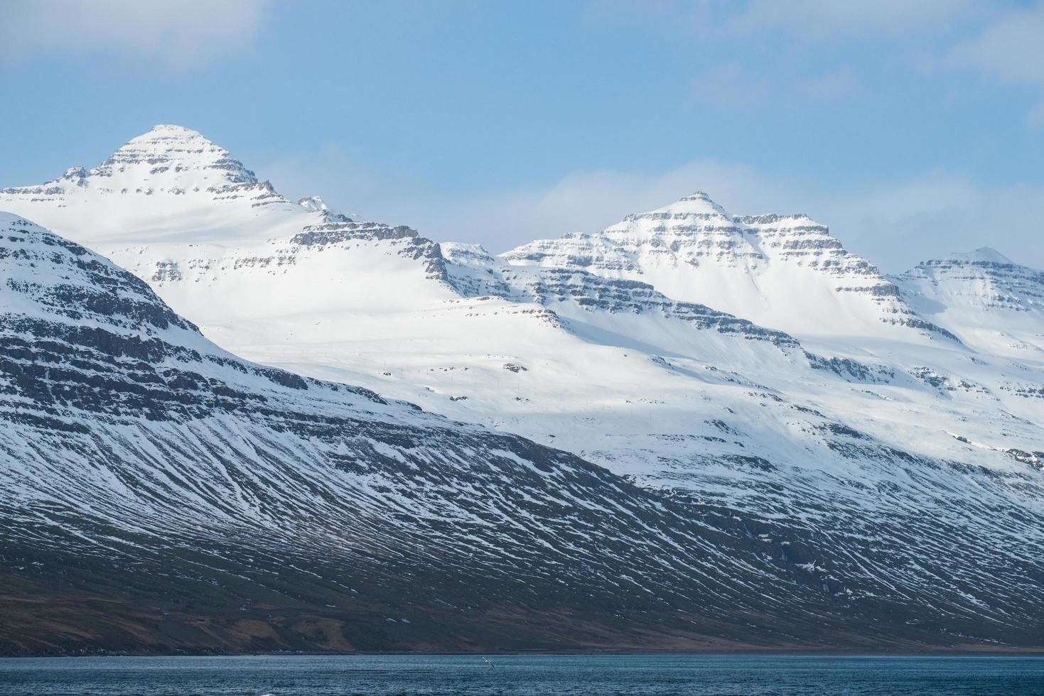 el hermoso paisaje de la montaña nevada en stodvarfjordur del este de islandia en la temporada de invierno. foto