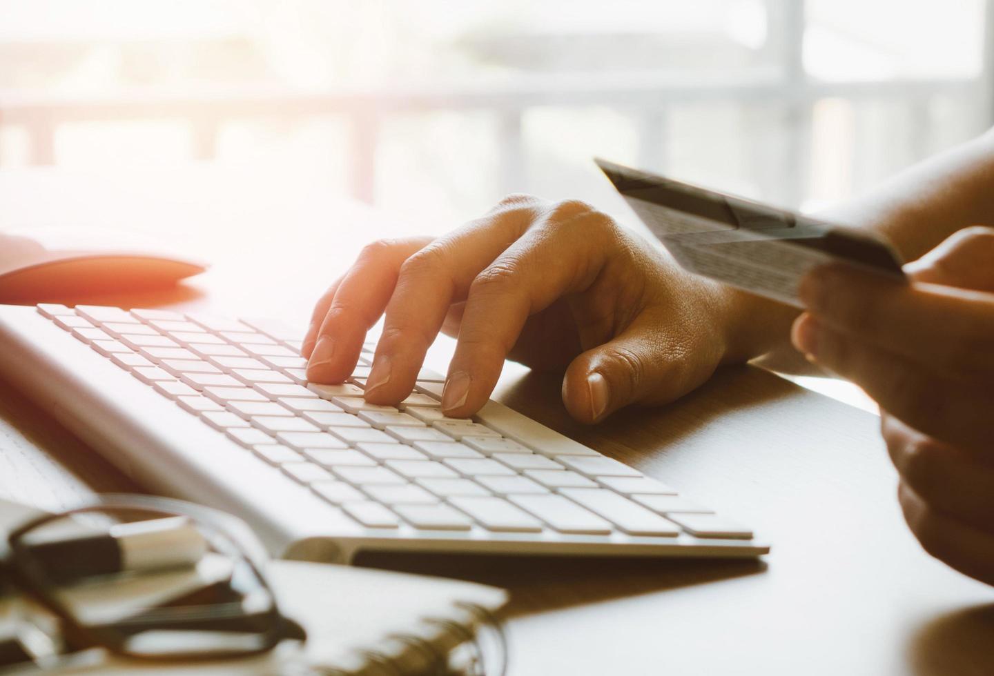 Hands holding credit card and using computer. Online shopping photo