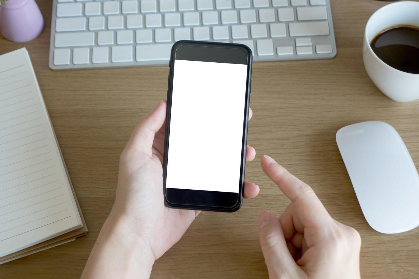 woman hands holding empty screen of smartphone on wood desk work photo