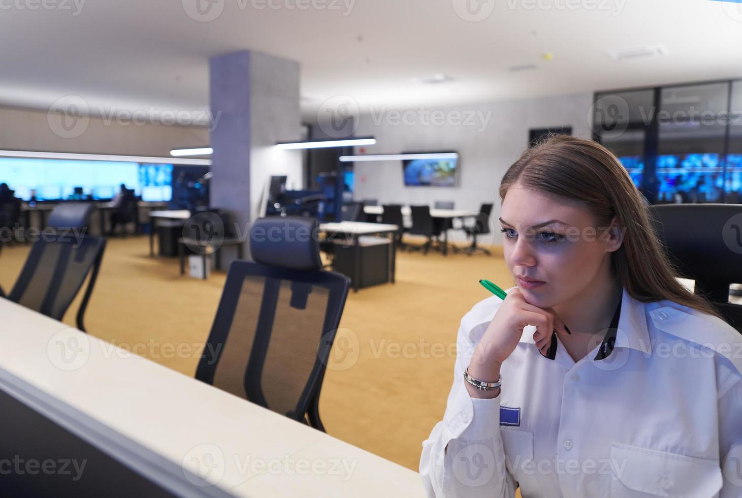 Female operator working in a security data system control room photo