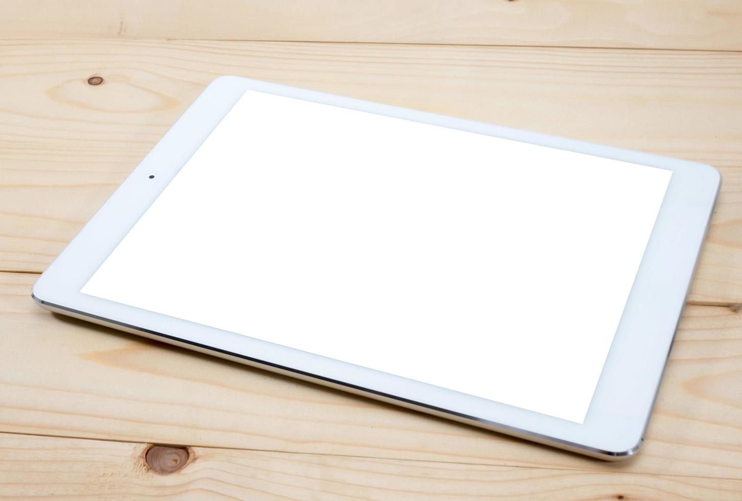 White tablet PC with blank screen on wooden table photo