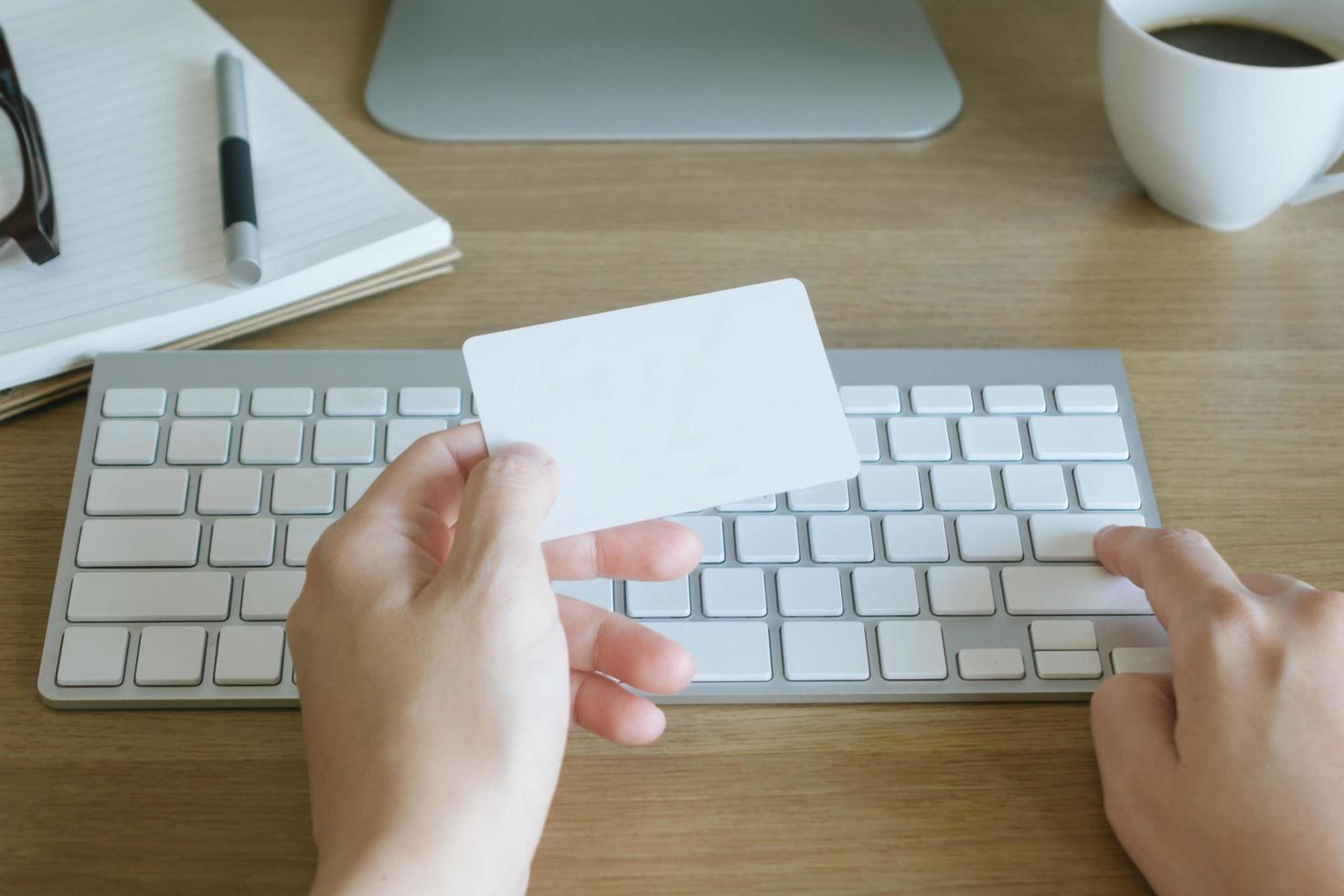 Hands holding credit card and using computer. Online shopping photo