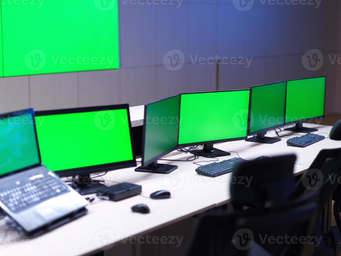 interior of big modern security system control room with blank green screens photo