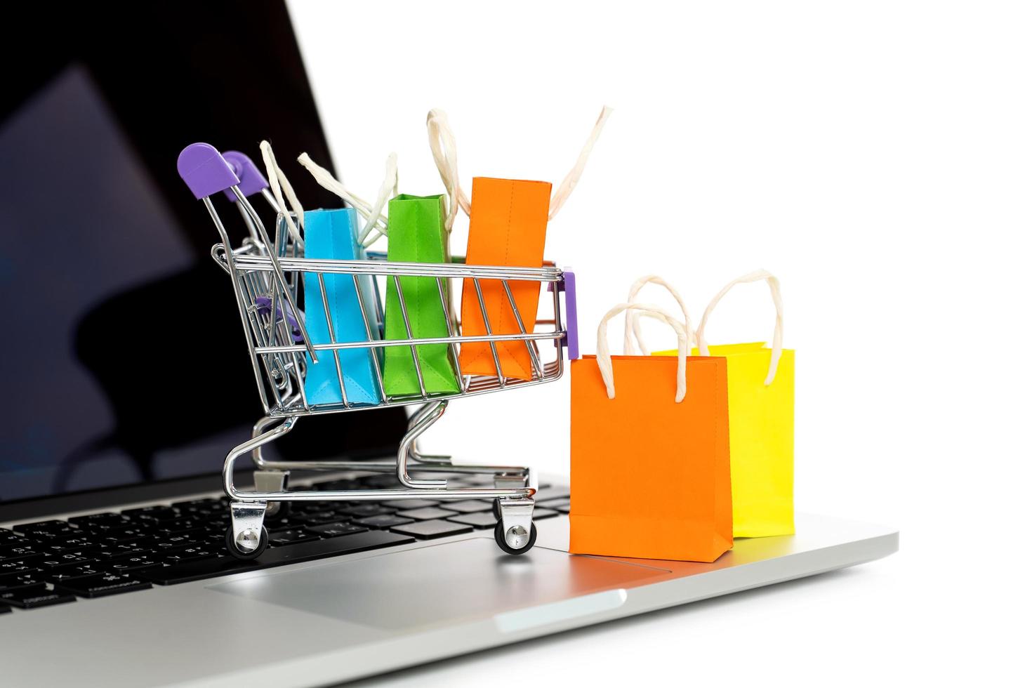 Shopping bag in a trolley with laptop computer on white background,Online shopping or ecommmerce concept,Easy shopping online concept photo