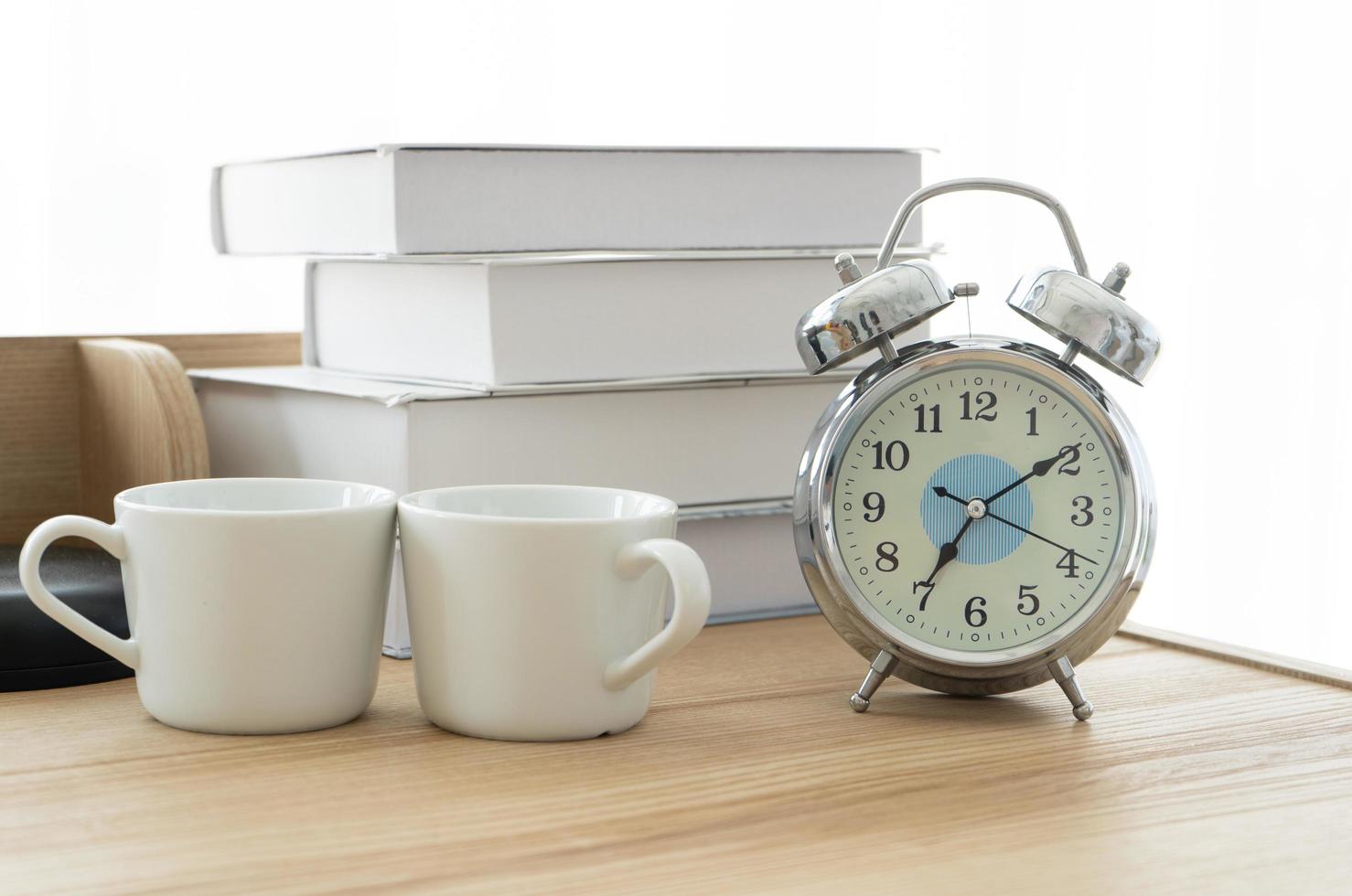 vintage alarm clock with white coffee cup isolated white background photo