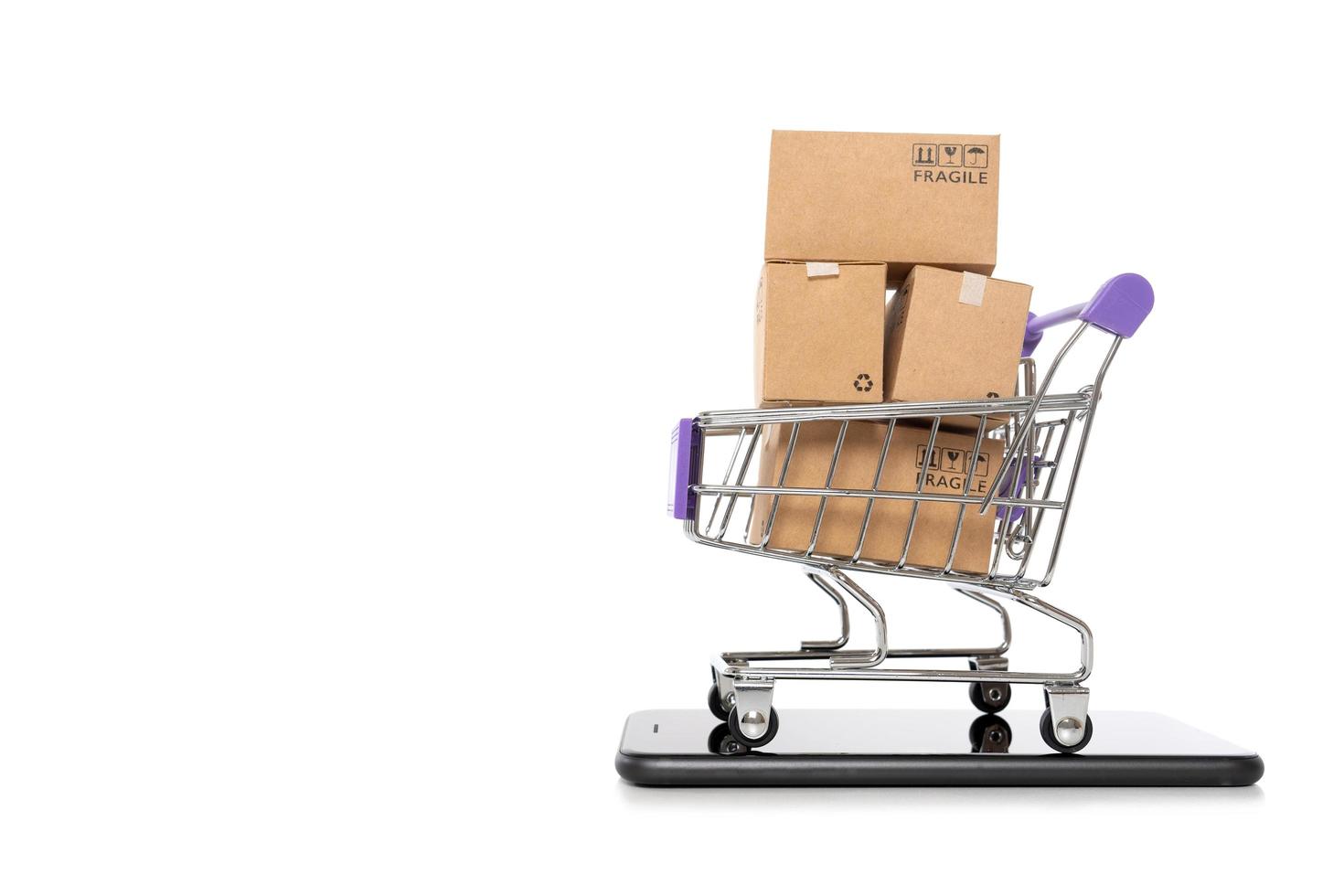 Paper boxes in a trolley with mobile phone on white background,Online shopping or ecommmerce concept photo