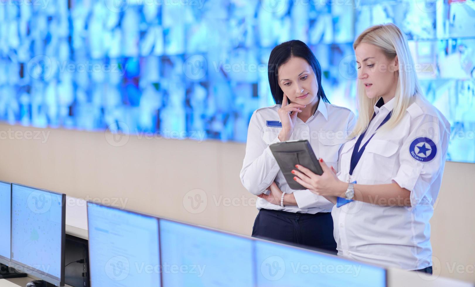 Female security guards working in a security data system control room photo