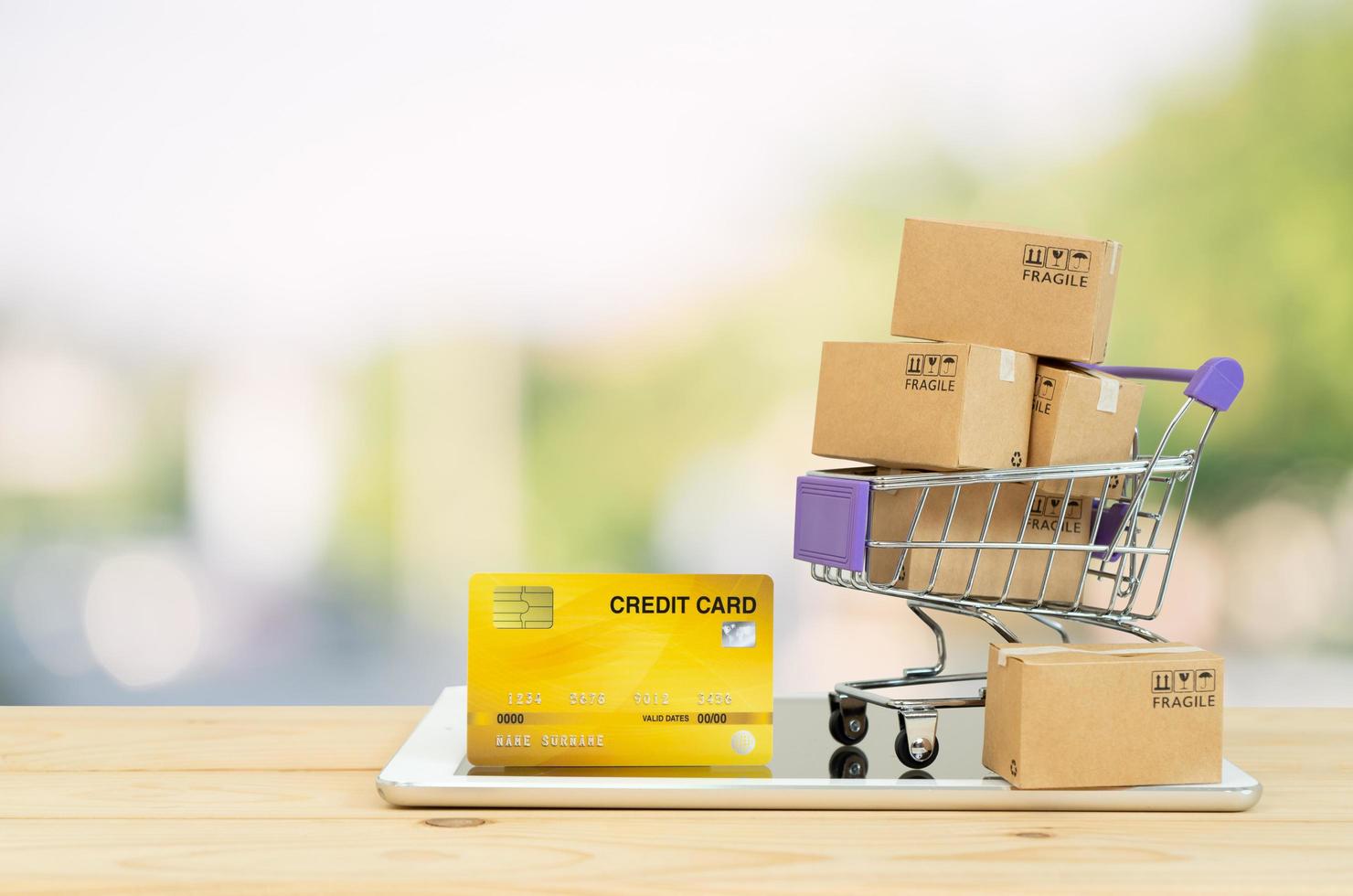 Paper boxes in a trolley with tablet on white background,Online shopping or ecommmerce concept photo