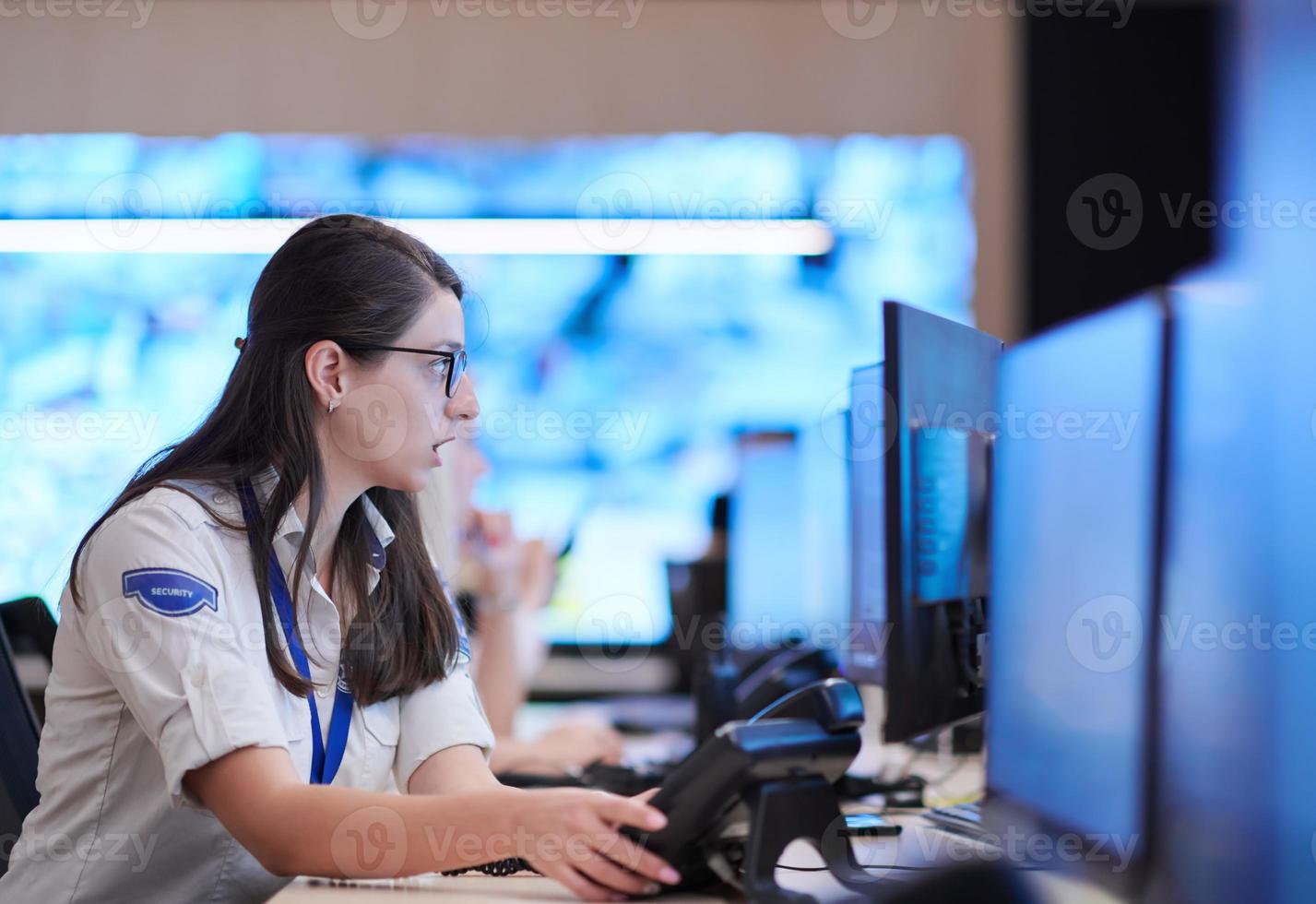 Female operator working in a security data system control room photo