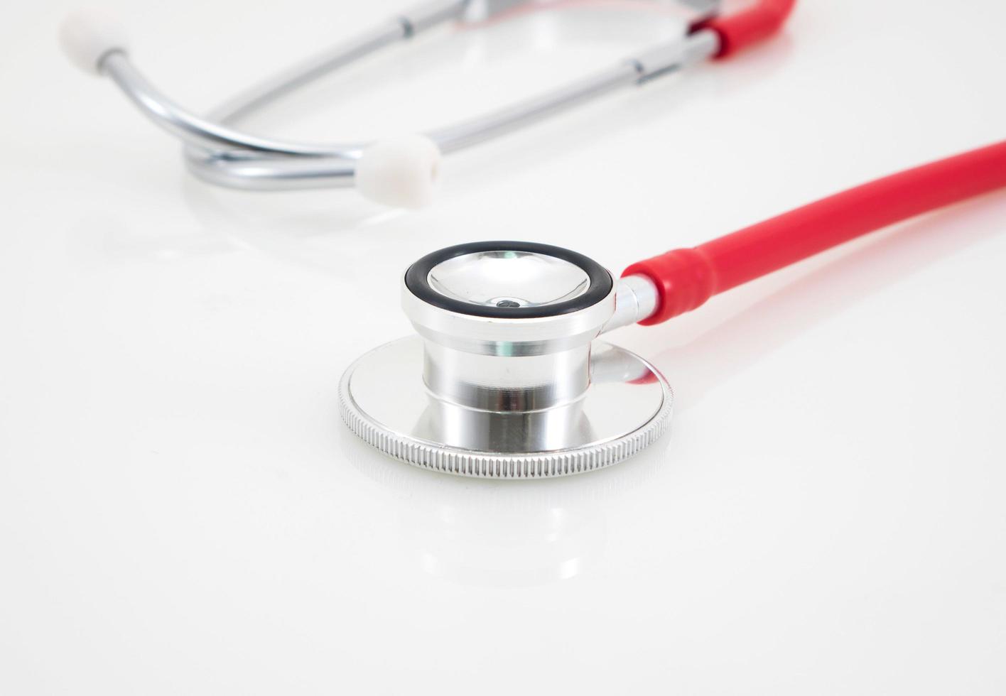 Red medical stethoscope isolated over the white background photo