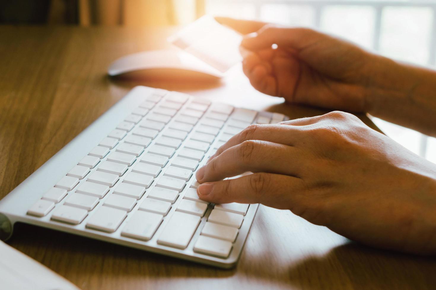 Hands holding credit card and using computer. Online shopping photo